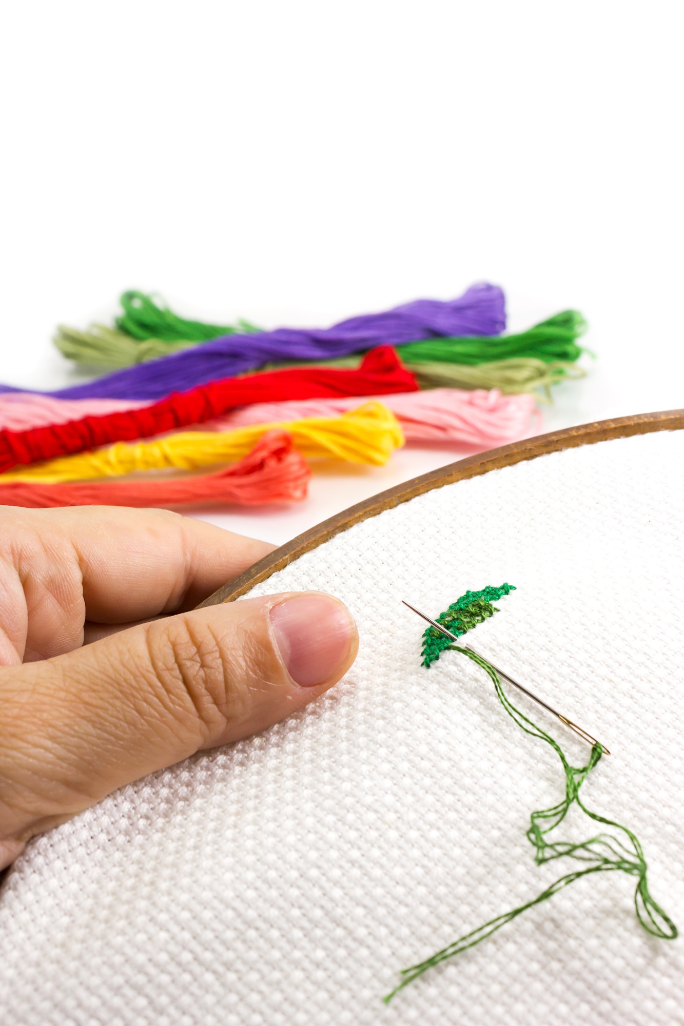 Close-up of hand embroidery on linen with playful color palette
